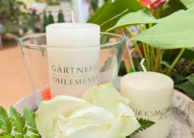 Dekoration mit weißer Rose, Kerzen und frischem Grün aus der Gärtnerei Ohlemeyer