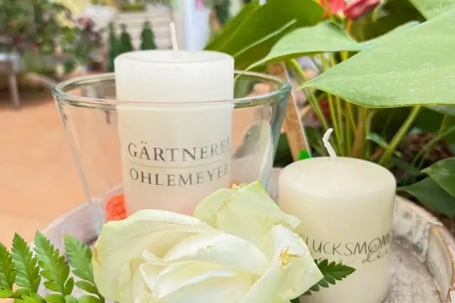 Dekoration mit weißer Rose, Kerzen und frischem Grün aus der Gärtnerei Ohlemeyer