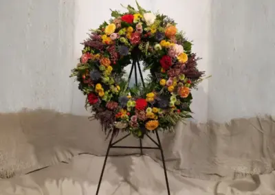 Bunter Blumenkranz mit roten, gelben und orangefarbenen Blüten und violetten Akzenten