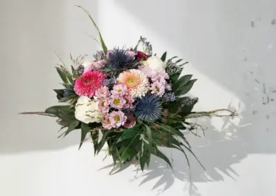 Bunter Blumenstrauß in Rosa, Weiß und Violett mit blauen Disteln und lockerem Grün