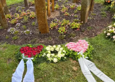 Herzförmige Trauergestecke aus roten, weißen und rosa Rosen