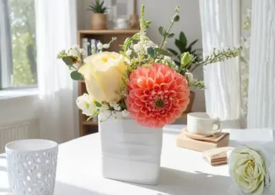Kleines Blumengesteck mit apricotfarbener Dahlie, cremefarbener Rose und zartem Grün