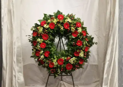 Trauerkranz mit roten Gerbera, weißen Blüten und grünem Beiwerk